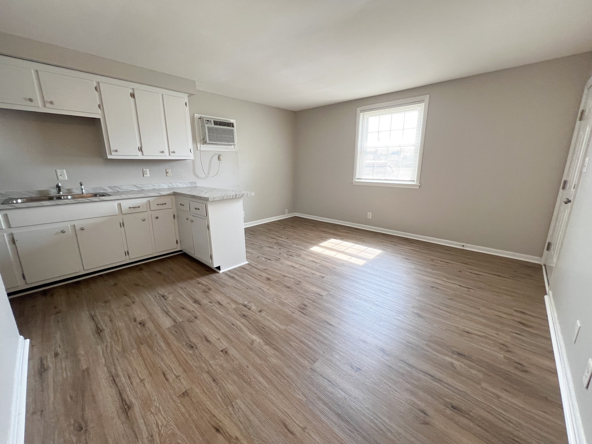 701 Power Street, Unit 1 Clarksville, TN 37042 - Photo 9 of 10 a kitchen with granite countertop white cabinets a sink and dishwasher with wooden floor