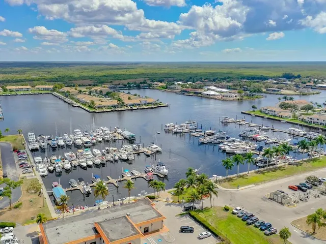 an aerial view of ocean and residential houses with outdoor space