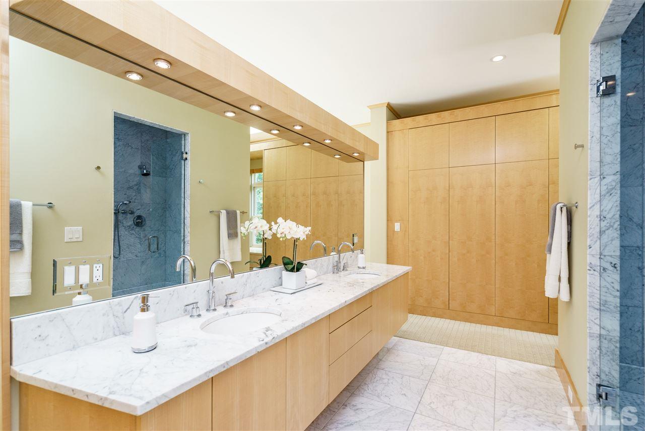 931 Vance Street Raleigh, NC 27608 - Photo 13 of 25 a en suite bathroom with a double vanity sink a mirror and a shower