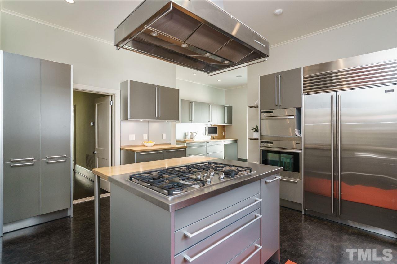 931 Vance Street Raleigh, NC 27608 - Photo 9 of 25 a kitchen with a refrigerator and a stove top oven