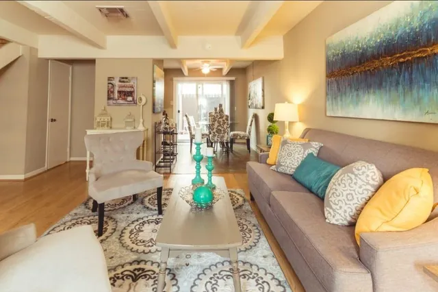 a living room with furniture and a wooden floor