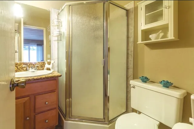 a bathroom with a granite countertop sink toilet and shower