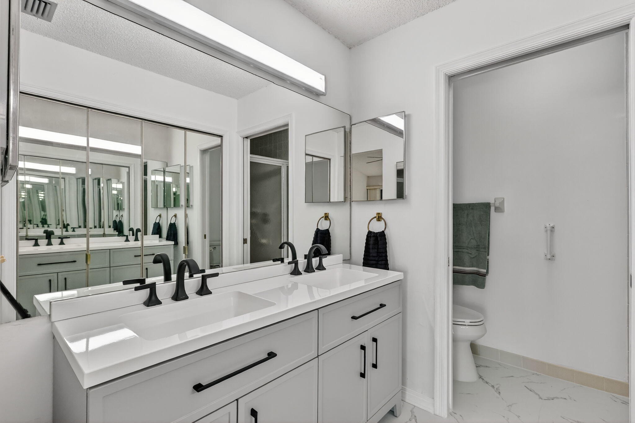 6184 Southeast Georgetown Place Hobe Sound, FL 33455 - Photo 15 of 29 a bathroom with a sink a toilet and a mirror