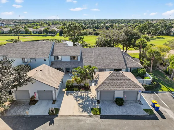 an aerial view of residential houses with outdoor space and ocean view