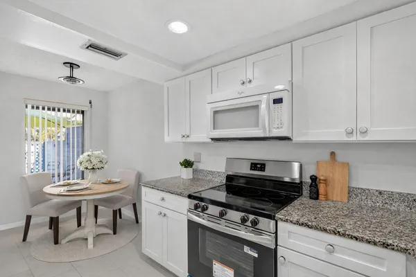a kitchen with white cabinets and appliances