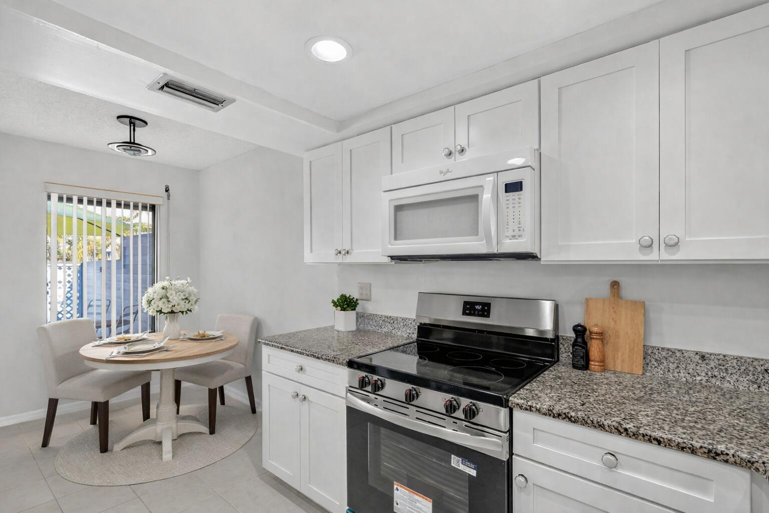 6184 Southeast Georgetown Place Hobe Sound, FL 33455 - Photo 7 of 29 a kitchen with white cabinets and appliances