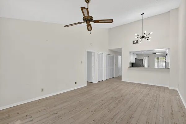a view of a livingroom with wooden floor and a ceiling fan
