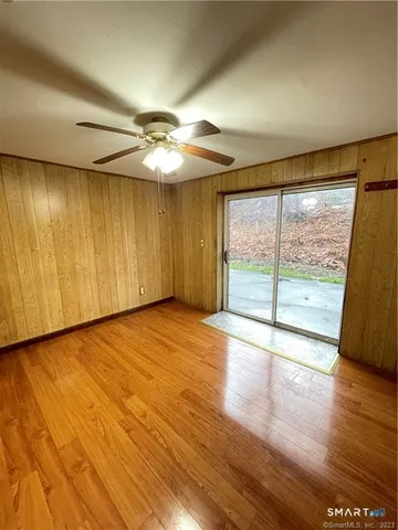 a view of empty room with wooden floor and fan