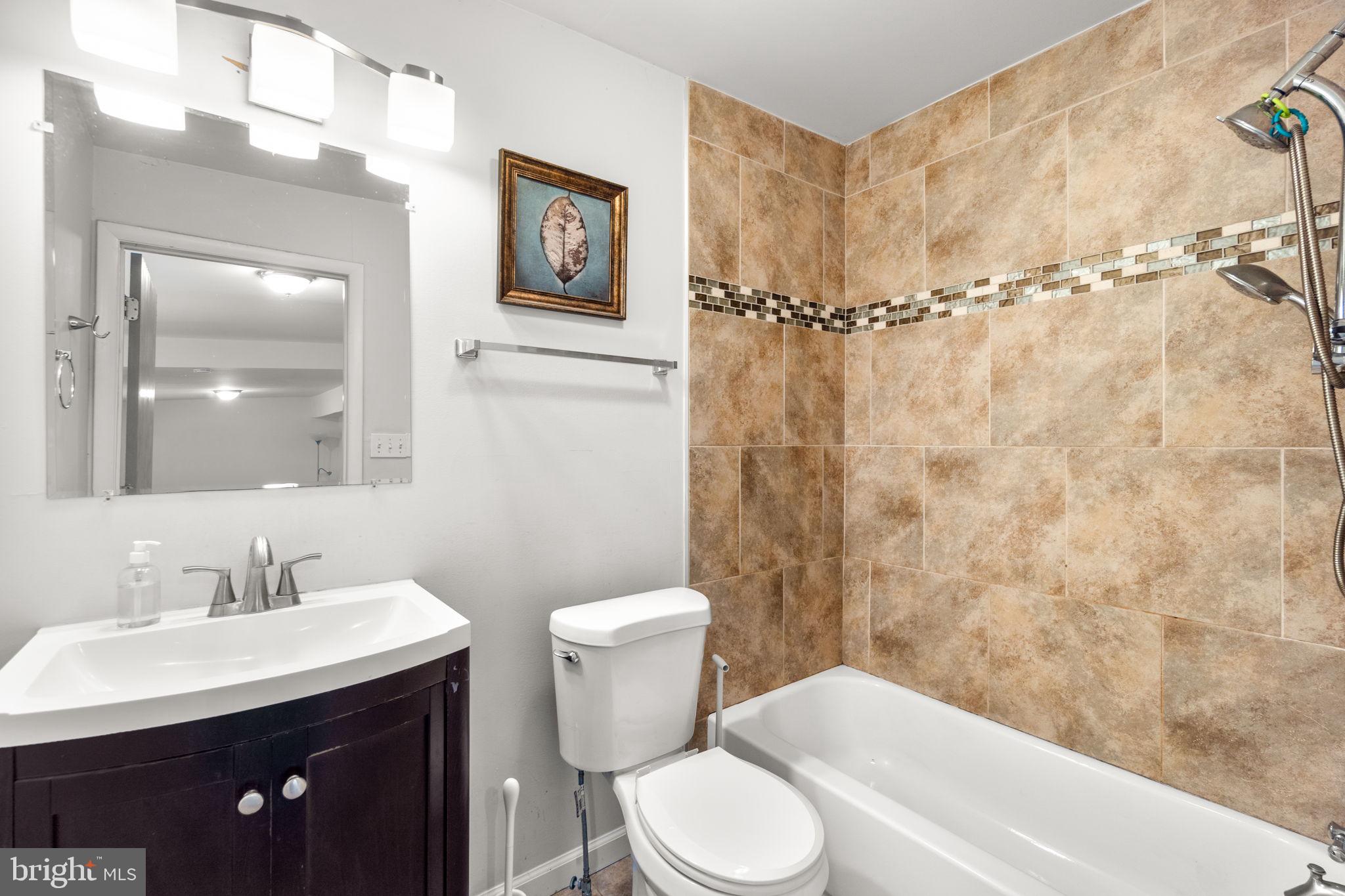 215 Cheddington Road Linthicum Heights, MD 21090 - Photo 17 of 41 a bathroom with a sink a toilet and shower
