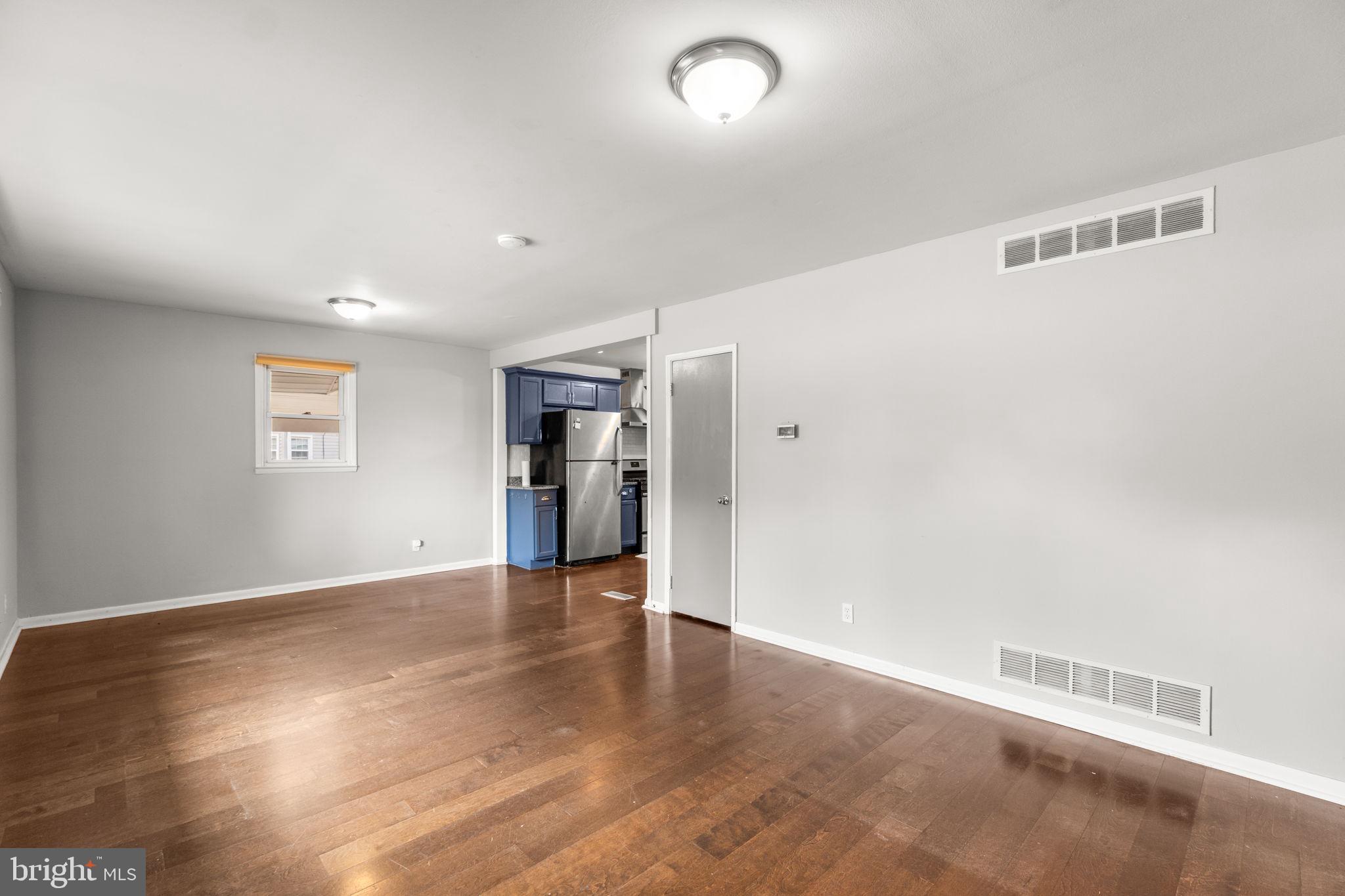 215 Cheddington Road Linthicum Heights, MD 21090 - Photo 4 of 41 a view of an empty room with wooden floor and a window