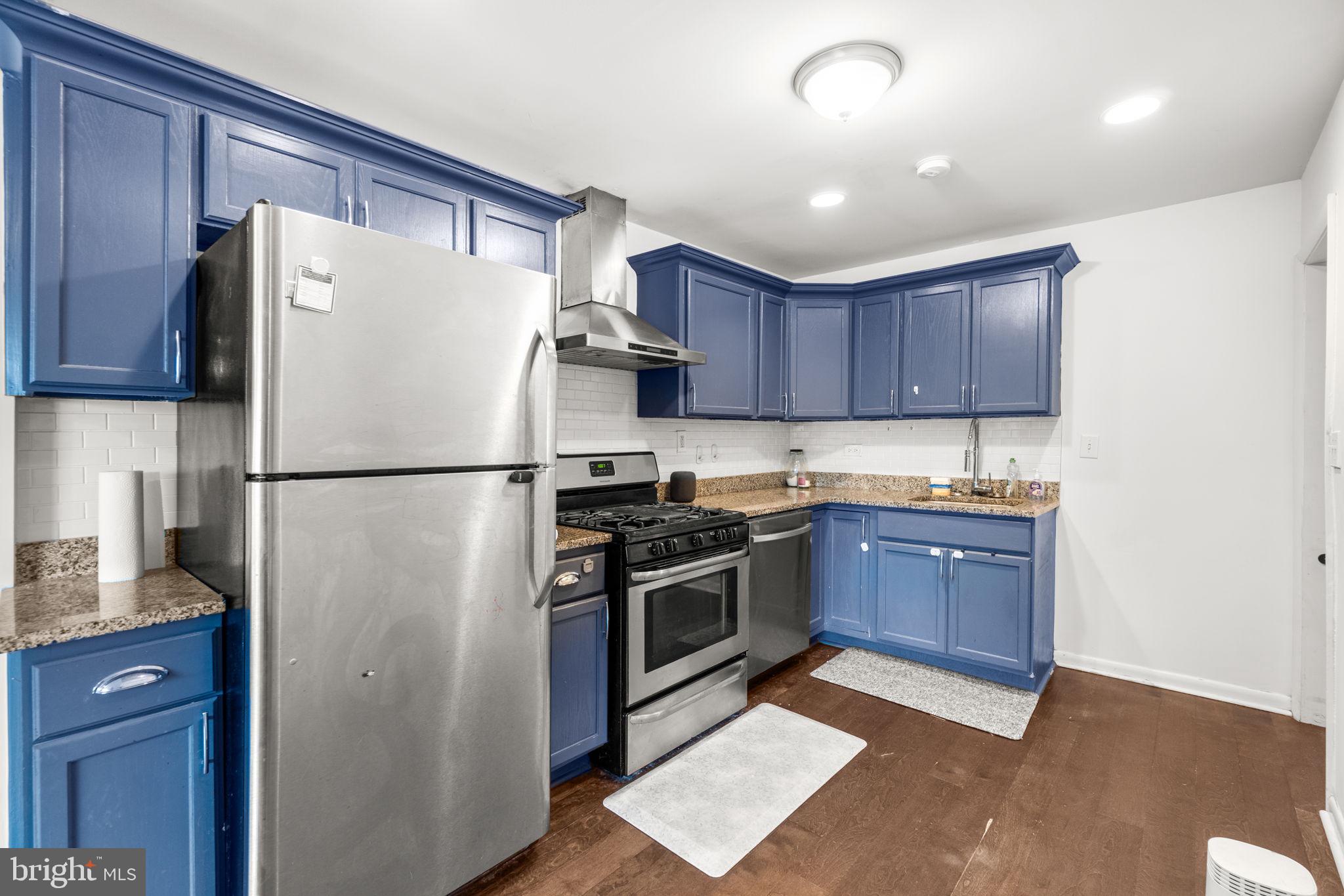 215 Cheddington Road Linthicum Heights, MD 21090 - Photo 9 of 41 a kitchen with stainless steel appliances granite countertop a refrigerator stove a sink and a granite counter tops with wooden floors
