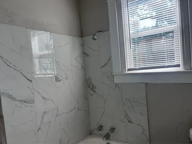 a bathroom with a window shower and vanity