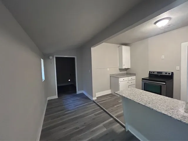 a kitchen with granite countertop a stove and cabinets