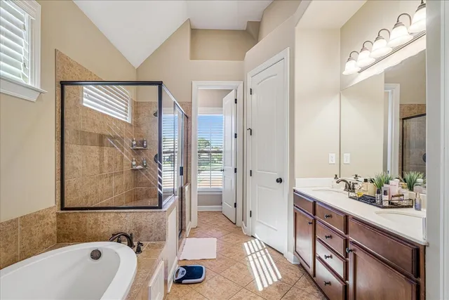 a bathroom with a tub sink and mirror