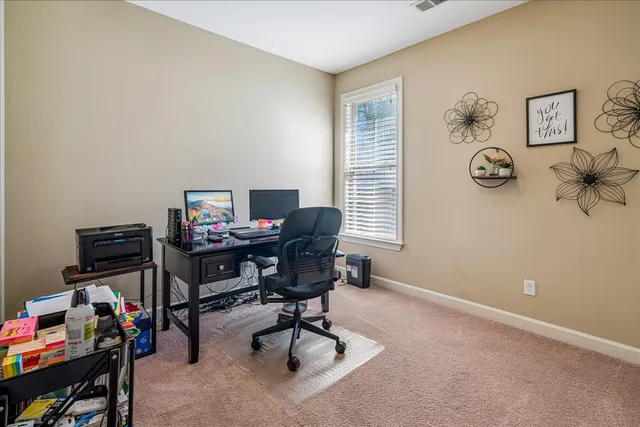 a view of a workspace with furniture and a window