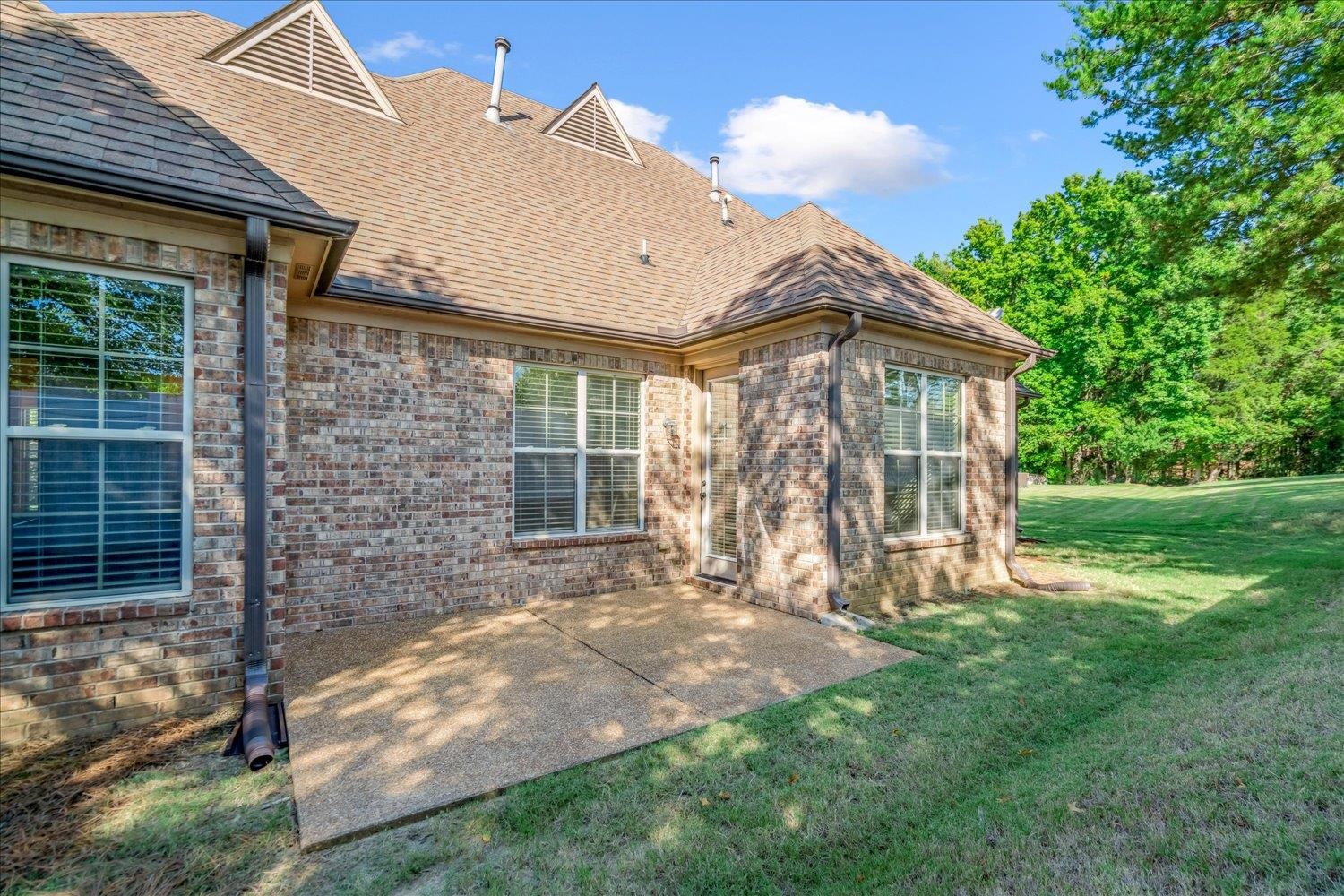 3230 Brunswick View Cove Bartlett, TN 38133 - Photo 31 of 32 Rear view of property featuring a lawn, a shingled roof, a patio, and brick siding