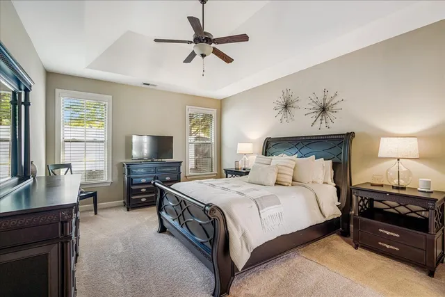 a spacious bedroom with a bed and a flat screen tv