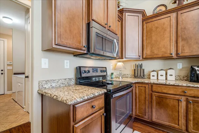 a kitchen with stainless steel appliances granite countertop a stove top oven a sink dishwasher and cabinets with wooden floor