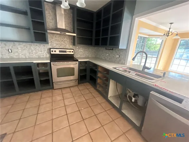 a kitchen with a sink a stove and cabinets