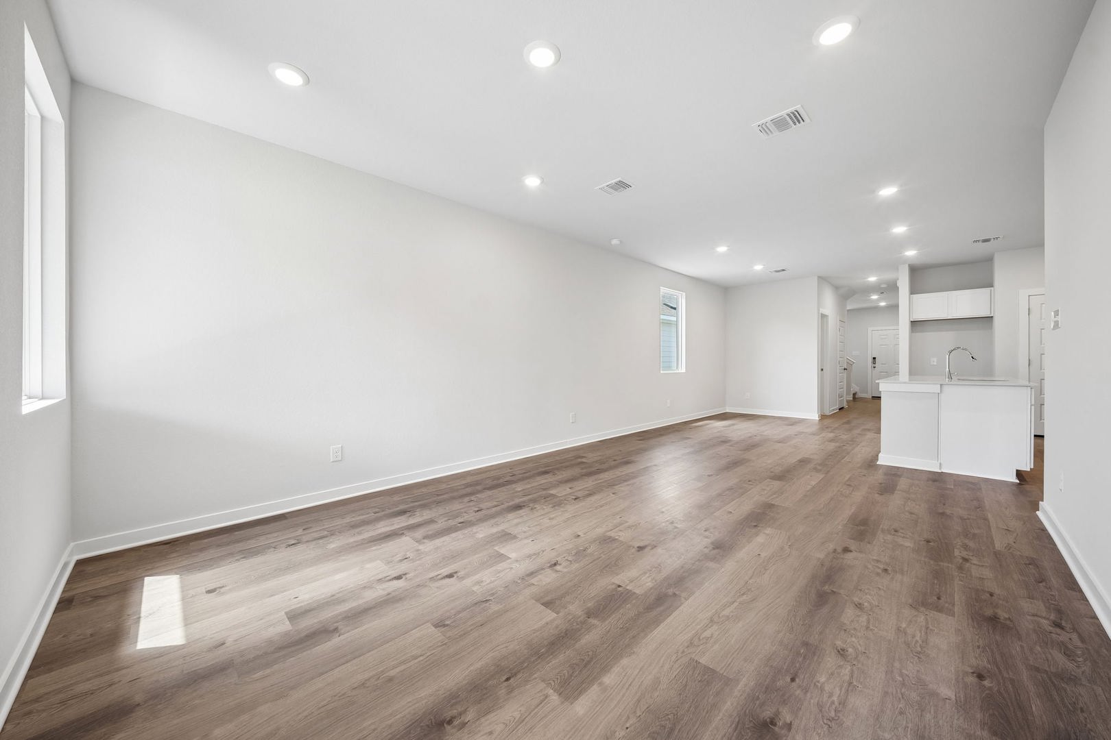 145 Hornet Street Elgin, TX 78621 - Photo 11 of 18 Recessed lighting and warm wood flooring define this versatile open-concept living space.