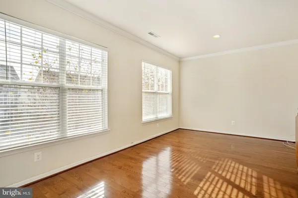 an empty room with wooden floor and a bathroom