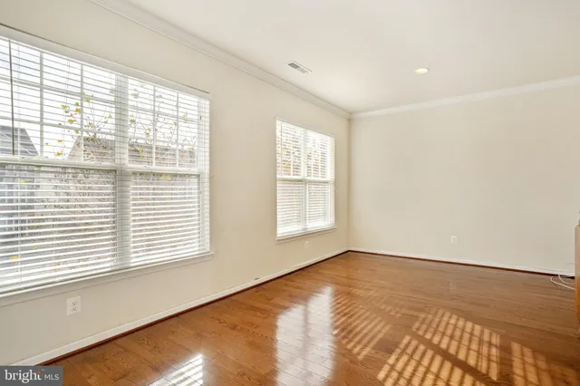 an empty room with wooden floor and a bathroom