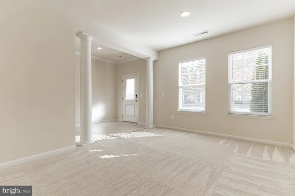 a view of an empty room with stairs and a window
