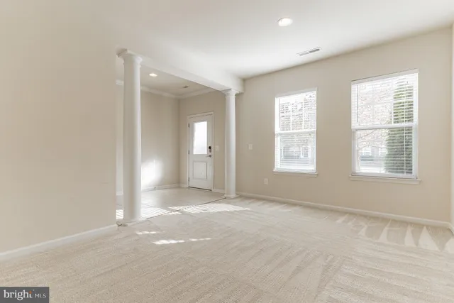 a view of an empty room with stairs and a window