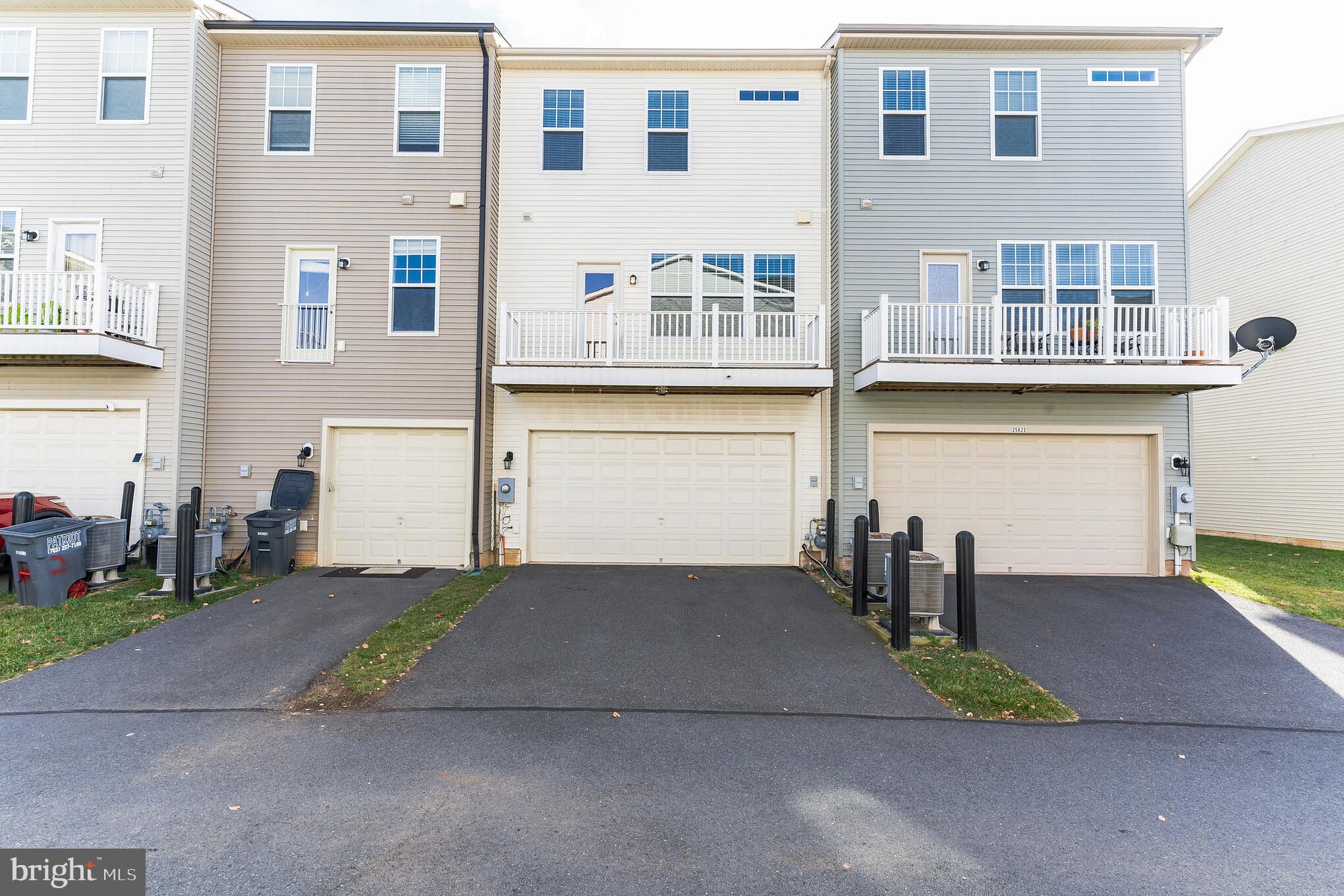 25621 Pleasant Valley Road Chantilly, VA 20152 - Photo 5 of 52 a front view of a house with a yard and garage