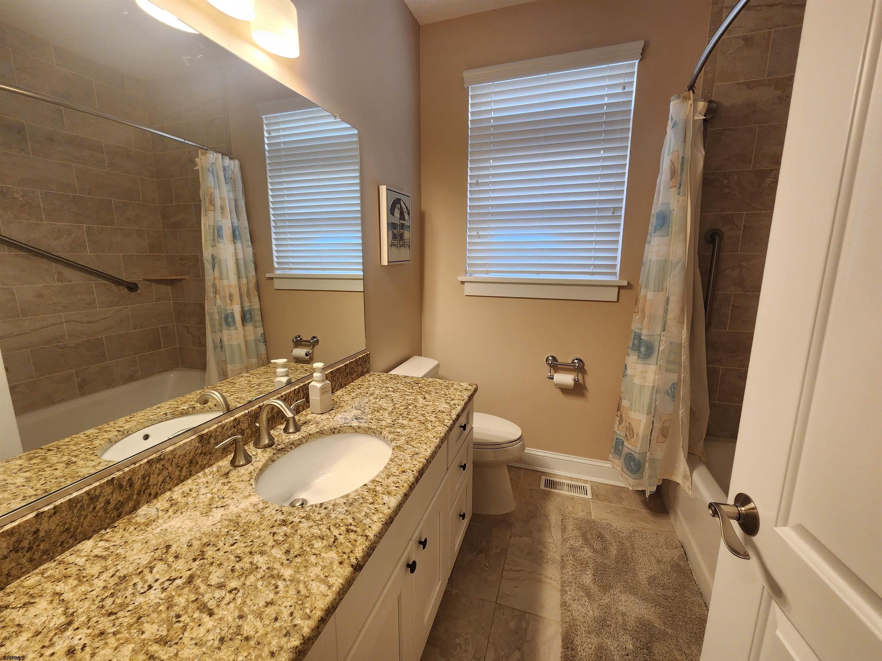 16 North Decatur Avenue, Unit 1 Margate City, NJ 08402 - Photo 11 of 29 a bathroom with a granite countertop sink and a mirror