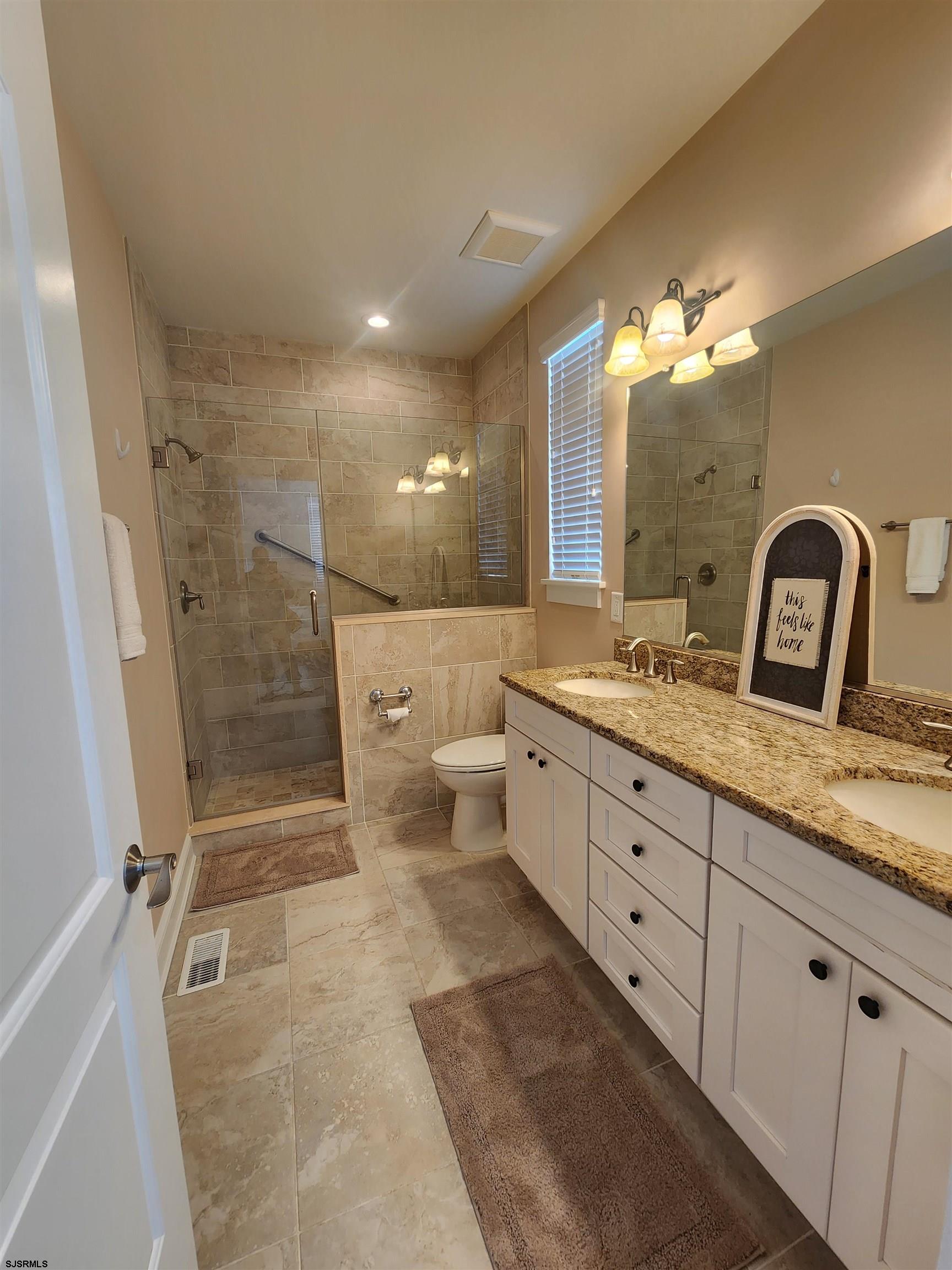 16 North Decatur Avenue, Unit 1 Margate City, NJ 08402 - Photo 21 of 29 a spacious bathroom with a double vanity sink a toilet and a mirror