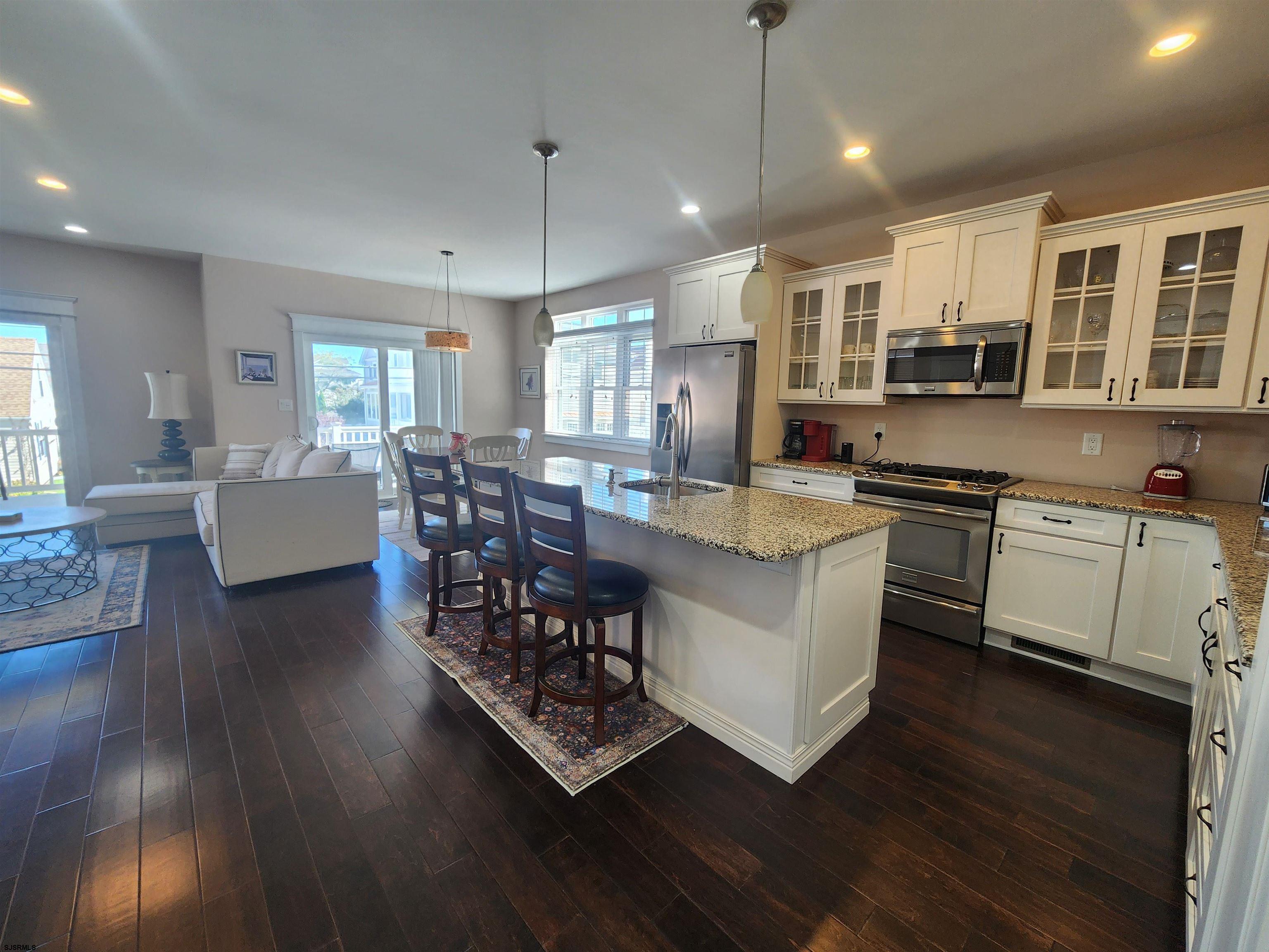 16 North Decatur Avenue, Unit 1 Margate City, NJ 08402 - Photo 5 of 29 a kitchen with stainless steel appliances granite countertop wooden floors and white cabinets