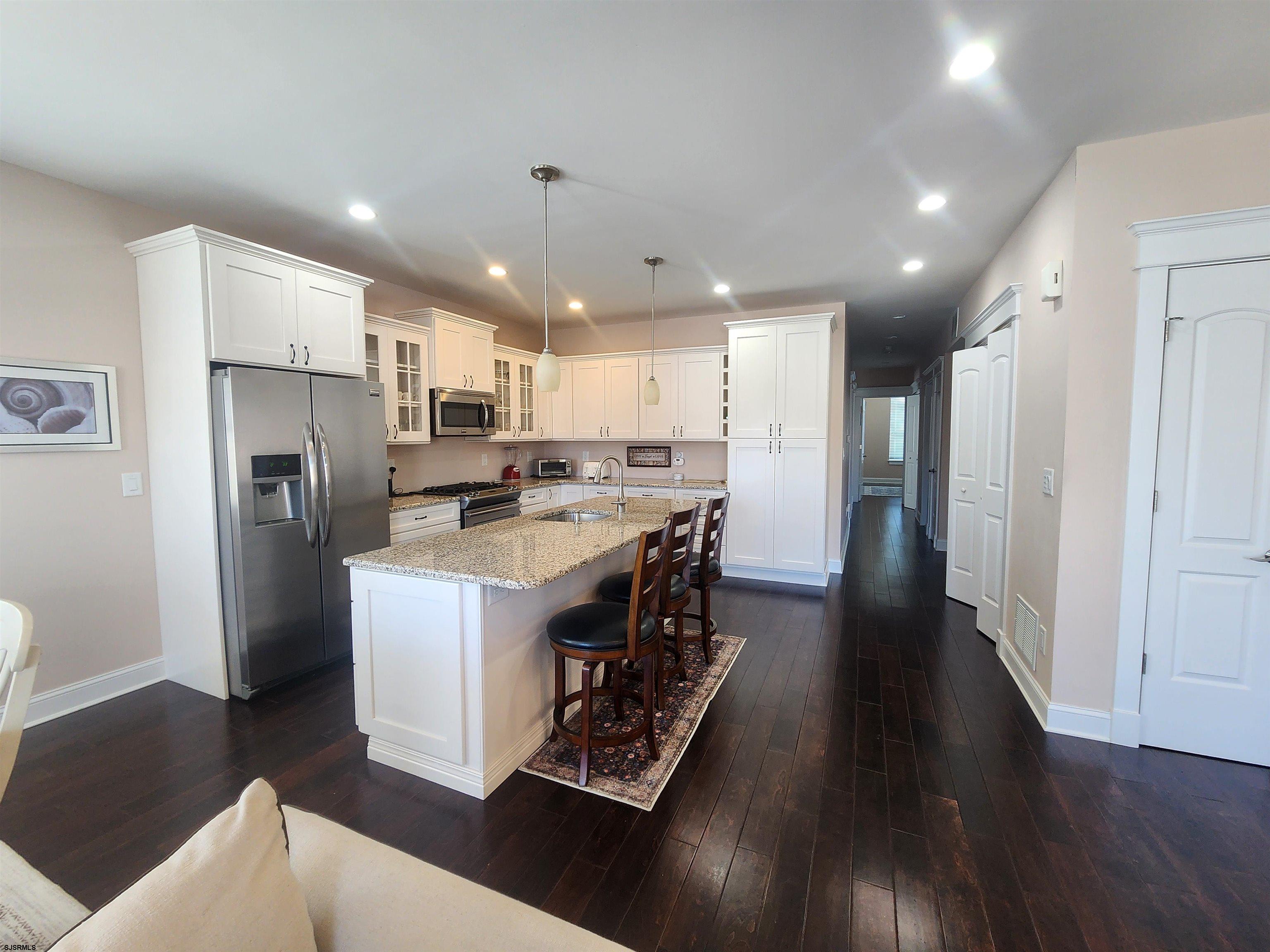 16 North Decatur Avenue, Unit 1 Margate City, NJ 08402 - Photo 6 of 29 a kitchen with stainless steel appliances granite countertop a refrigerator a stove a sink dishwasher and a refrigerator with wooden floor