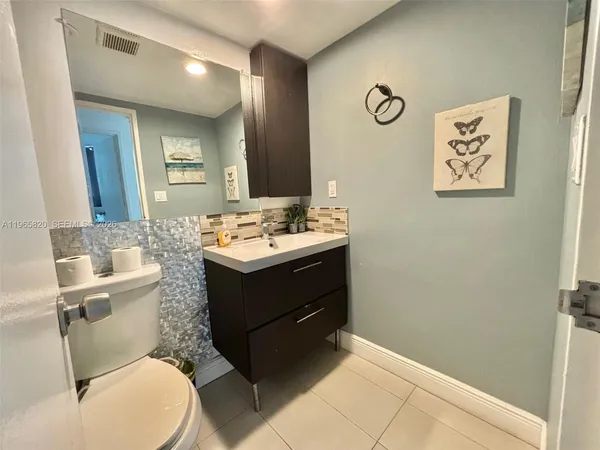 a bathroom with a toilet sink vanity and mirror