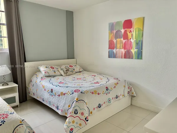 a bedroom with a bed and painting on the wall