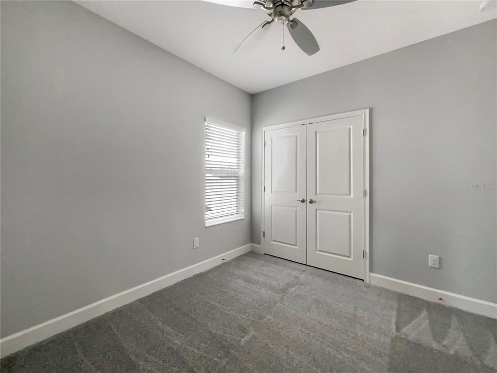 705 Winterside Drive Apollo Beach, FL 33572 - Photo 17 of 30 an empty room with a chandelier fan and windows