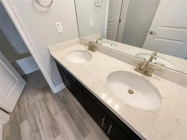 a bathroom with a double vanity sink and a mirror