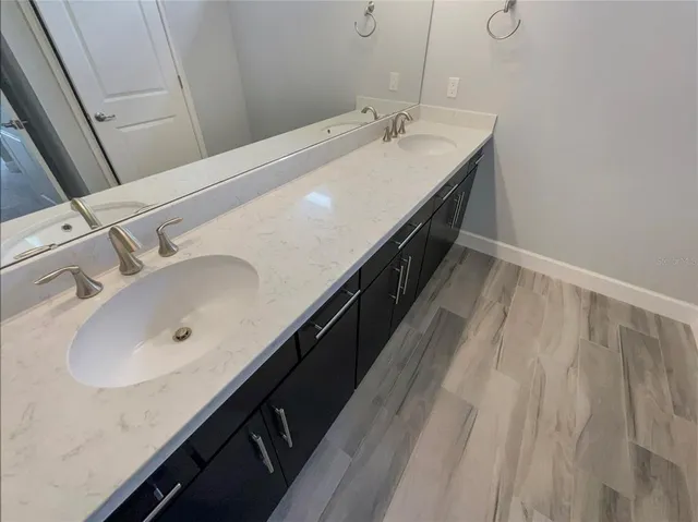 a bathroom with a double vanity sink and mirror