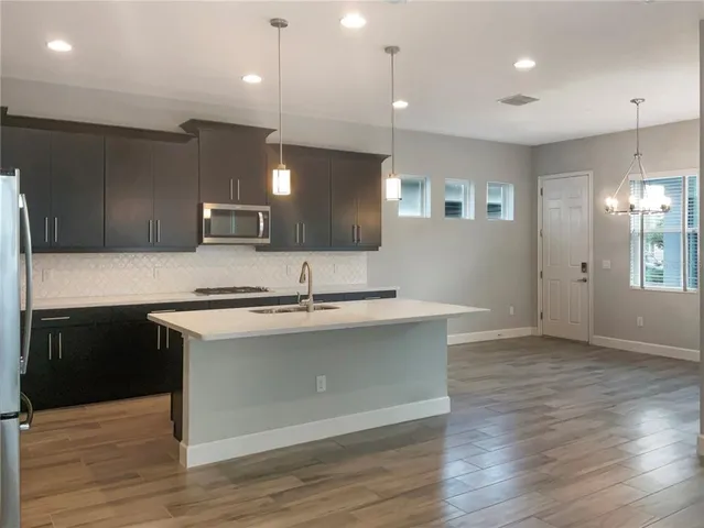 a kitchen with a sink cabinets and wooden floor