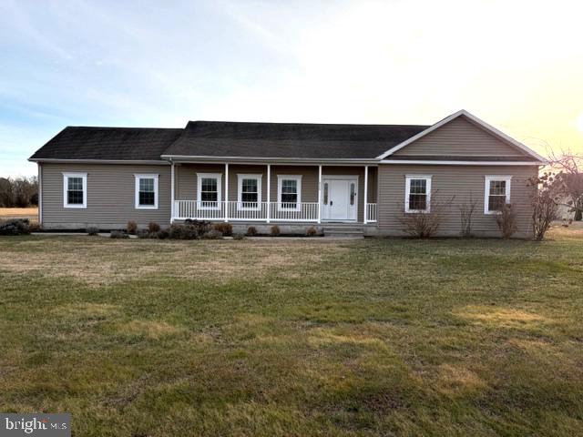 a front view of house with yard and trees in the background