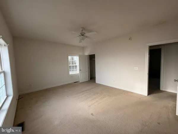 an empty room with windows and closet