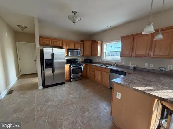 a kitchen with stainless steel appliances granite countertop a stove a sink a refrigerator and island