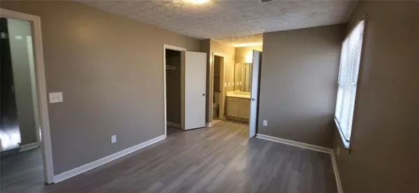 an empty room with wooden floor and entrance