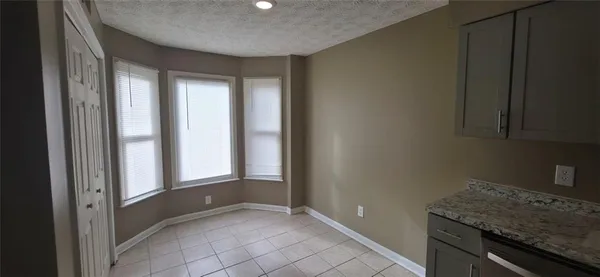 a view of an empty room with a kitchen