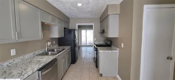 a kitchen with stainless steel appliances granite countertop a sink a stove and a refrigerator