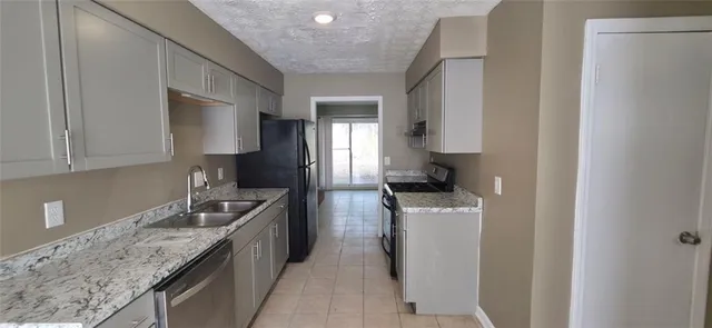 a kitchen with stainless steel appliances granite countertop a sink a stove and a refrigerator