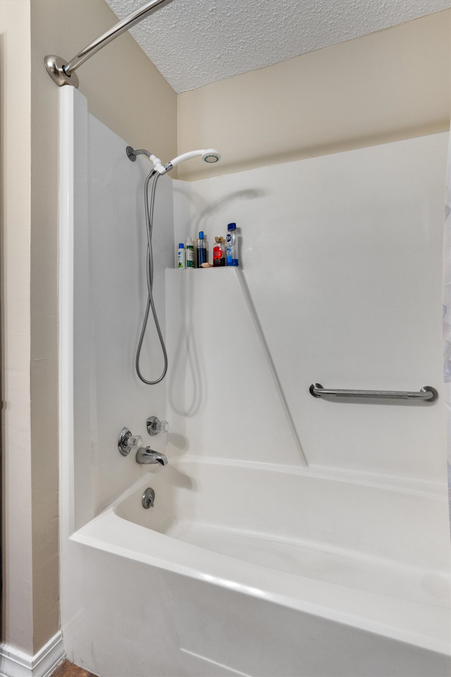 401 Drake Lane Taylor, TX 76574 - Photo 21 of 31 White acrylic bathtub with shower kit featuring a handheld showerhead