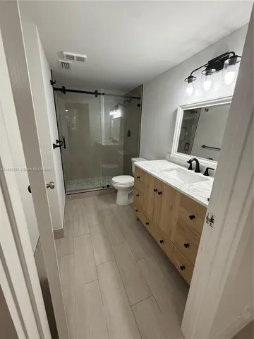 a bathroom with a double vanity sink toilet and shower