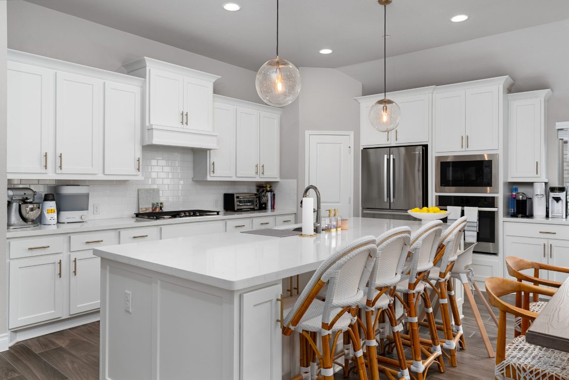 6105 Fadden Road Austin, TX 78738 - Photo 11 of 40 a kitchen with stainless steel appliances a stove center island a refrigerator and cabinets
