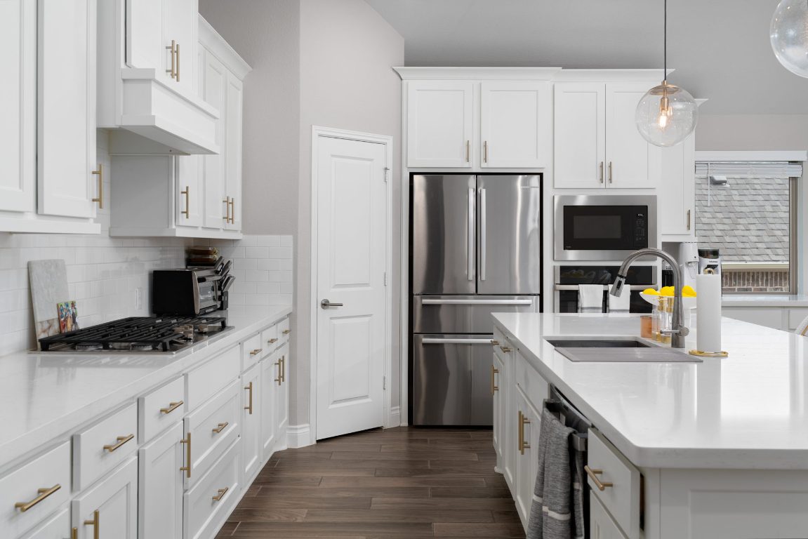 6105 Fadden Road Austin, TX 78738 - Photo 14 of 40 a kitchen with granite countertop a refrigerator a sink a stove and oven